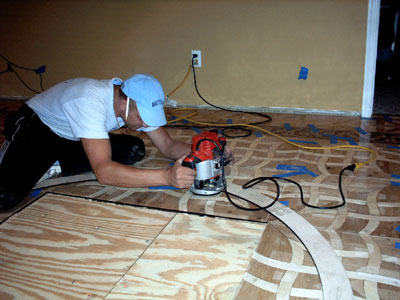 Using router and medallion template the floor is cut to fit the wood flooring medallion Using router and template the floor is cut to fit the wood floor medallion